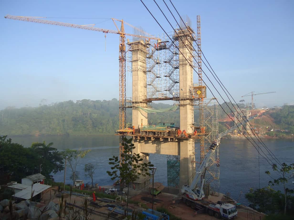 Una vista dalla riva brasiliana e l’avanzamento dei piloni; montata la gru a torre, sono state installate le scale di servizio esterne, interne ed un elevatore